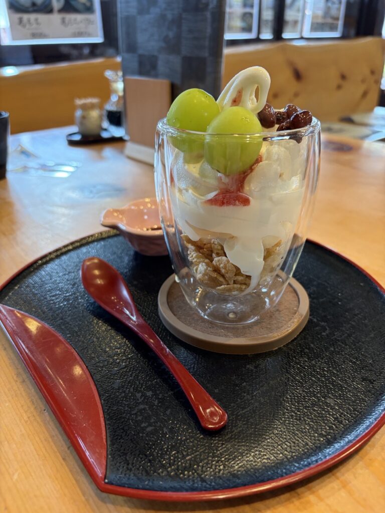 熊川宿まる志んの季節のフルーツパフェ 緑色のぶどうとクリームを盛り付け