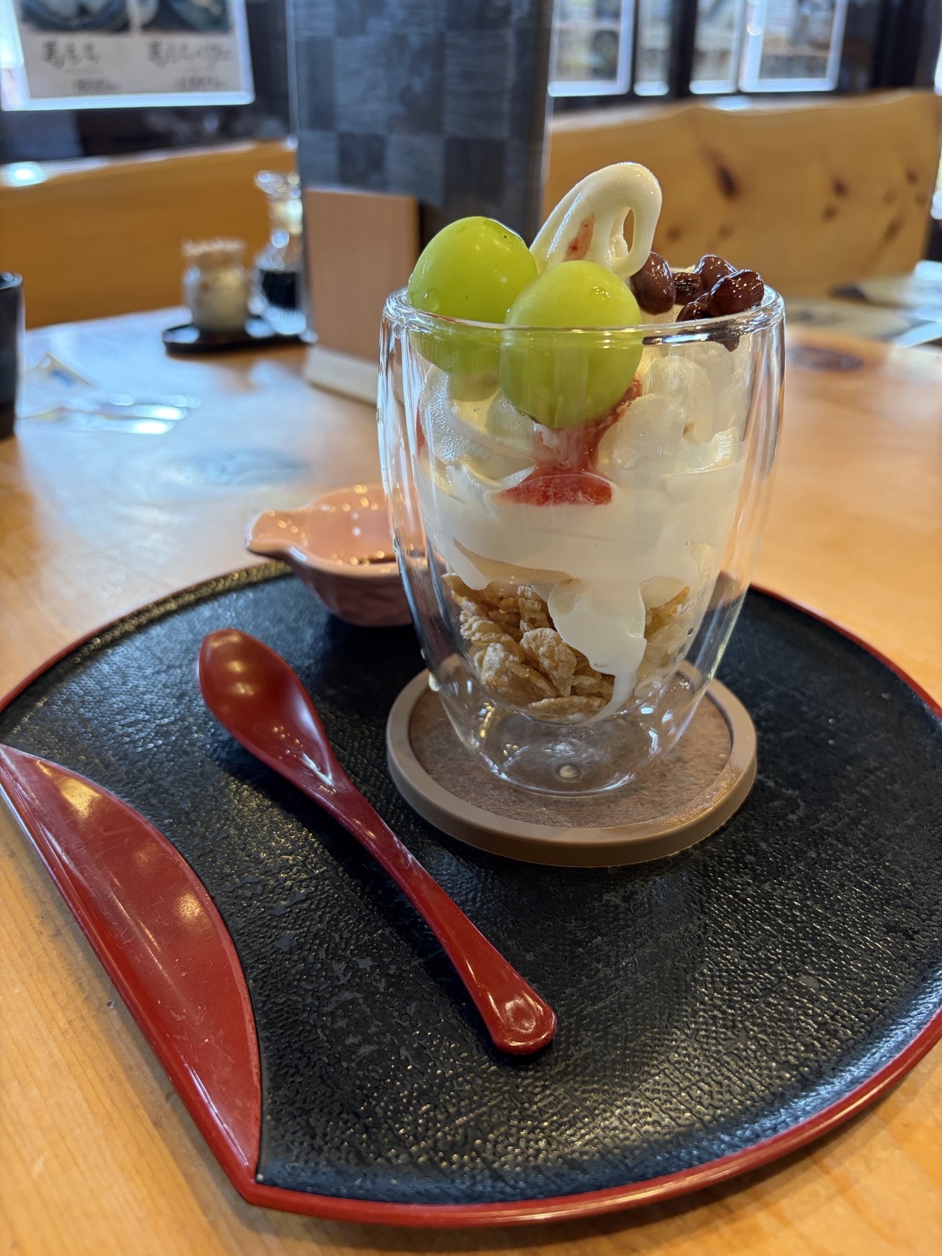 熊川宿まる志んの季節のフルーツパフェ 緑色のぶどうとクリームを盛り付け